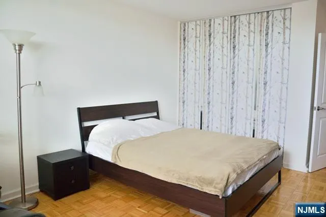 a large bed sitting in a bedroom next to a window