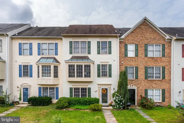 front view of a brick house with a yard