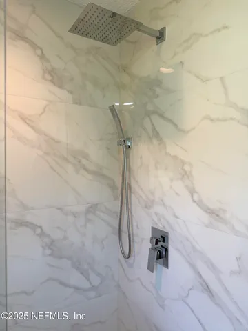 a view of a white house with a small yard and a large tree