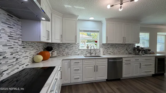 a kitchen with stainless steel appliances granite countertop a sink a stove and cabinets