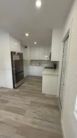 a view of a hallway with wooden floor and closet