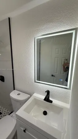 a bathroom with a sink toilet and shower