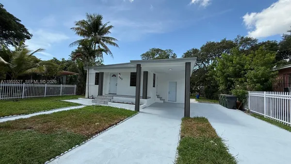 a view of a house with a yard and potted plants