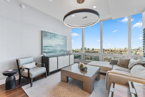 a living room with furniture a table and kitchen view