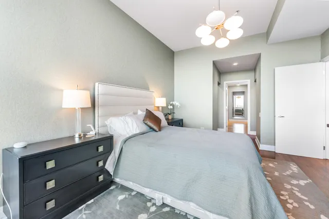 a bedroom with a bed and a chandelier