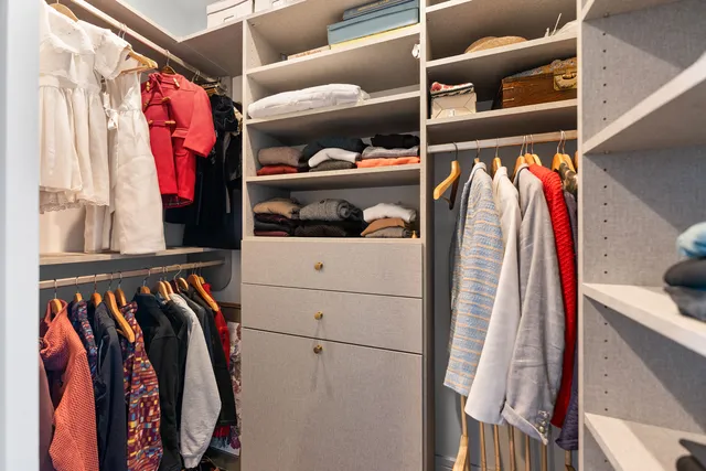 a view of walk in closet with clothes and shoes