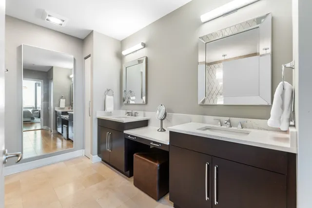 a bathroom with a sink double vanity granite tub shower and a mirror