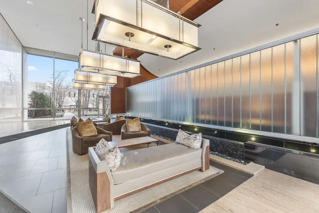 a living room with couches and large glass windows with a rug