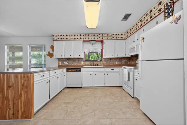 a large white kitchen with a large window