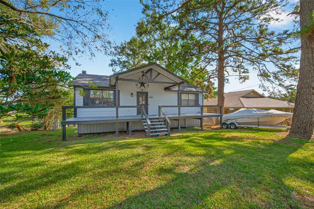 a view of a house with a big yard and large tree