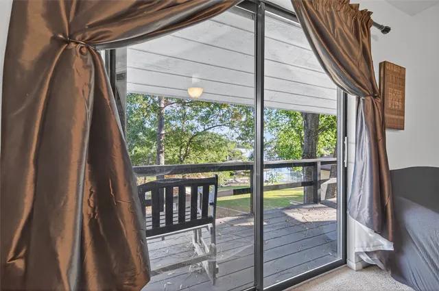a view of a yard with plants and large trees