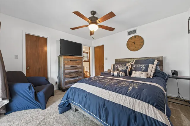 a bedroom with a large bed and a chandelier
