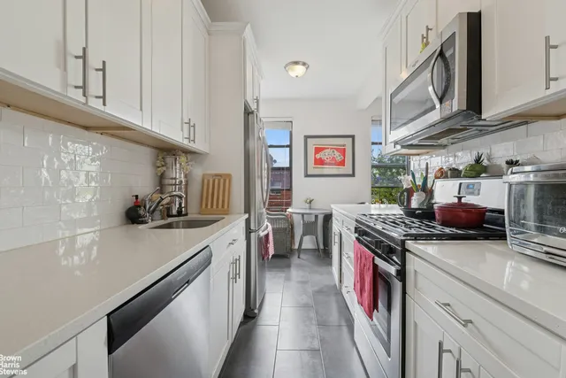 a kitchen with granite countertop a sink a stove and cabinets