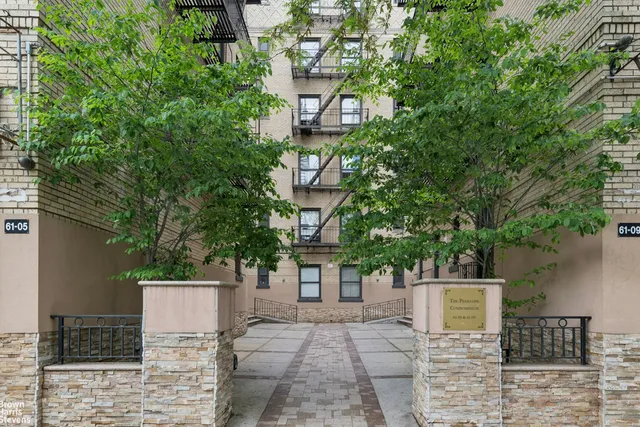 a front view of a house with a tree
