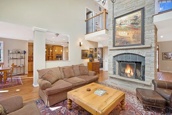 a living room with furniture a fireplace and a large window