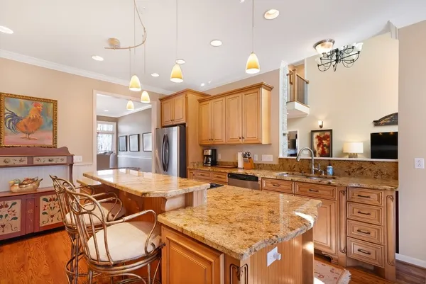 a large kitchen with kitchen island granite countertop a large counter top appliances and cabinets