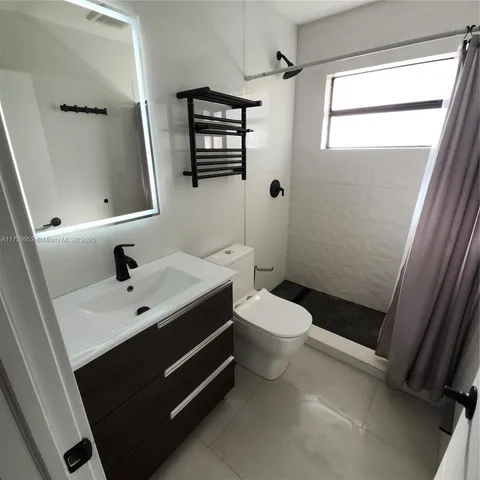 a bathroom with a toilet a sink and shower