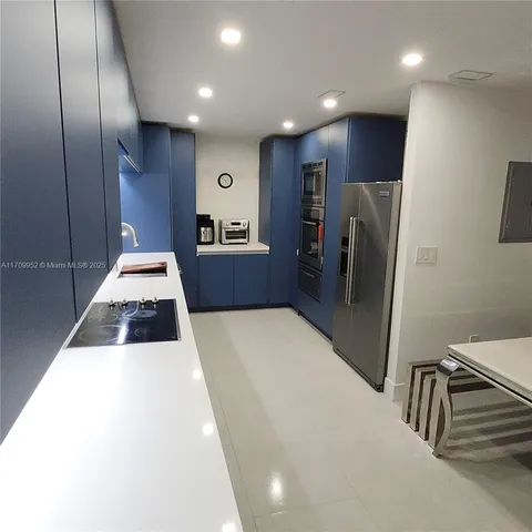 a kitchen with stainless steel appliances a refrigerator and a stove top oven