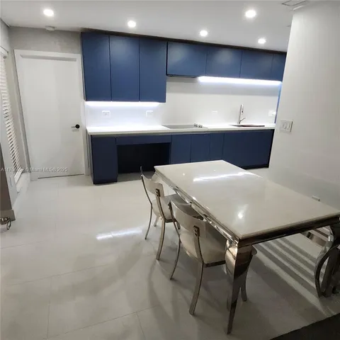 a kitchen with stainless steel appliances a table and chairs