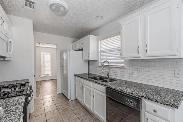 a kitchen with stainless steel appliances granite countertop a sink stove and cabinets