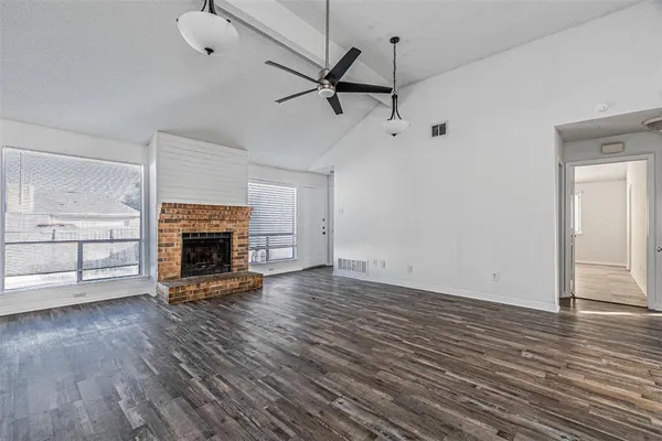 a view of empty room with wooden floor fireplace and windows