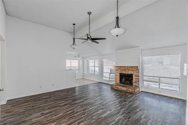 a view of an empty room with a fireplace and a window