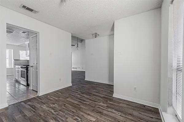 an empty room with wooden floor and a bathroom