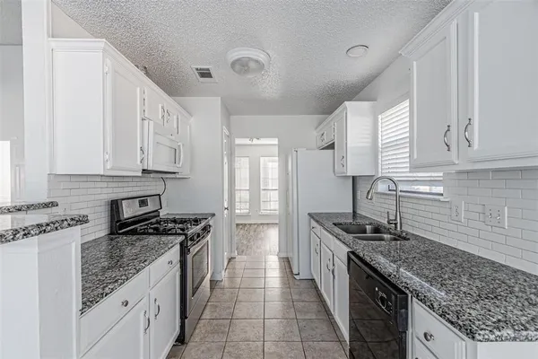 a kitchen with stainless steel appliances granite countertop a sink stove and cabinets