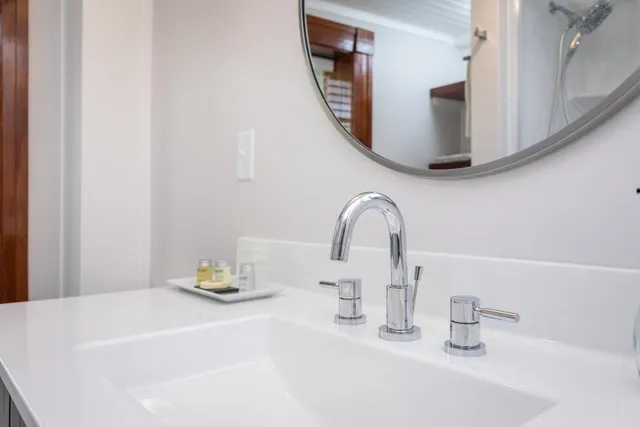 a living room with stainless steel appliances furniture a rug and a window