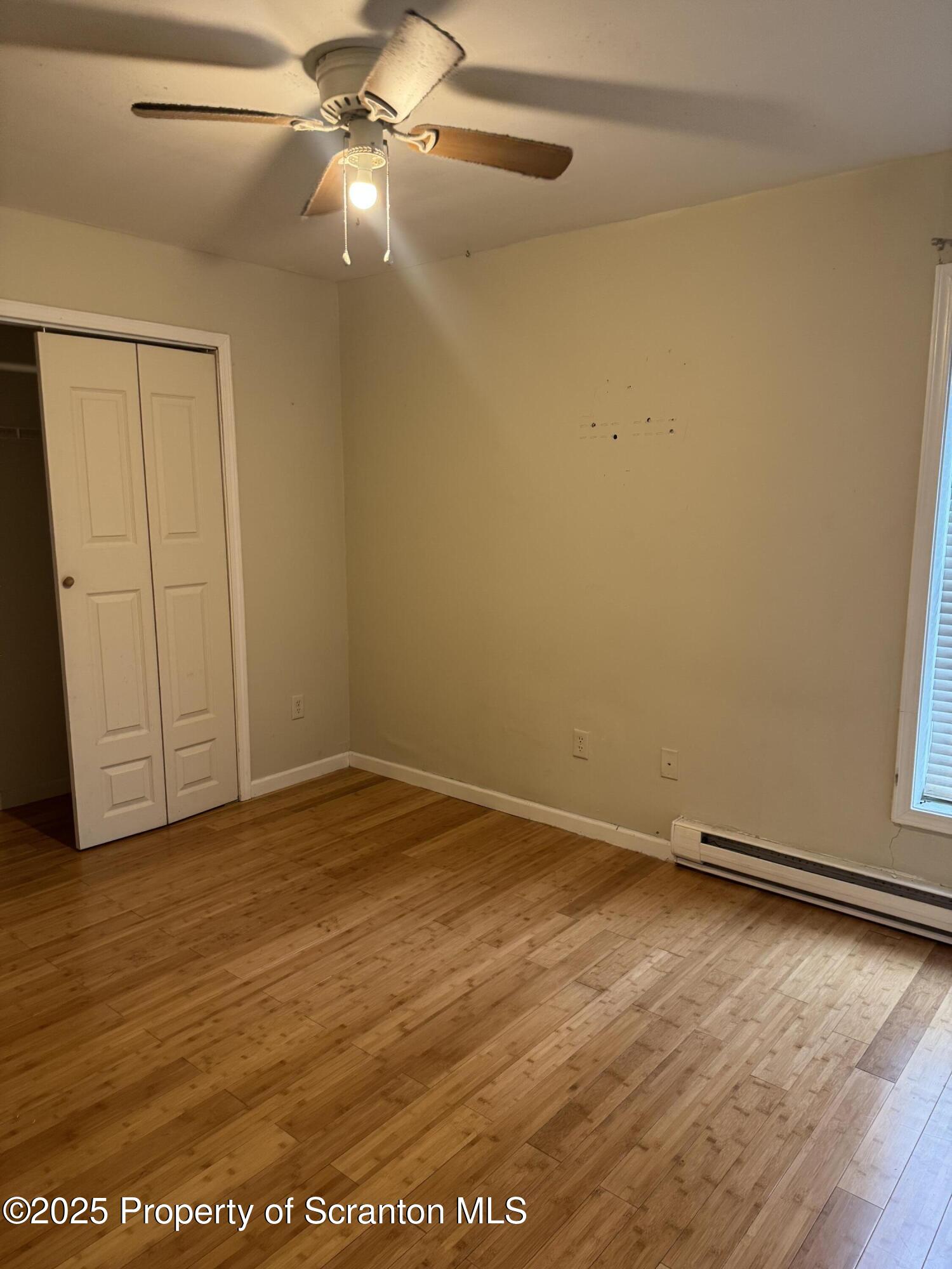 114 Prospect Avenue, Unit 1ST FL FRONT Scranton, PA 18505 - Photo 4 of 10 an empty room with wooden floor and fan