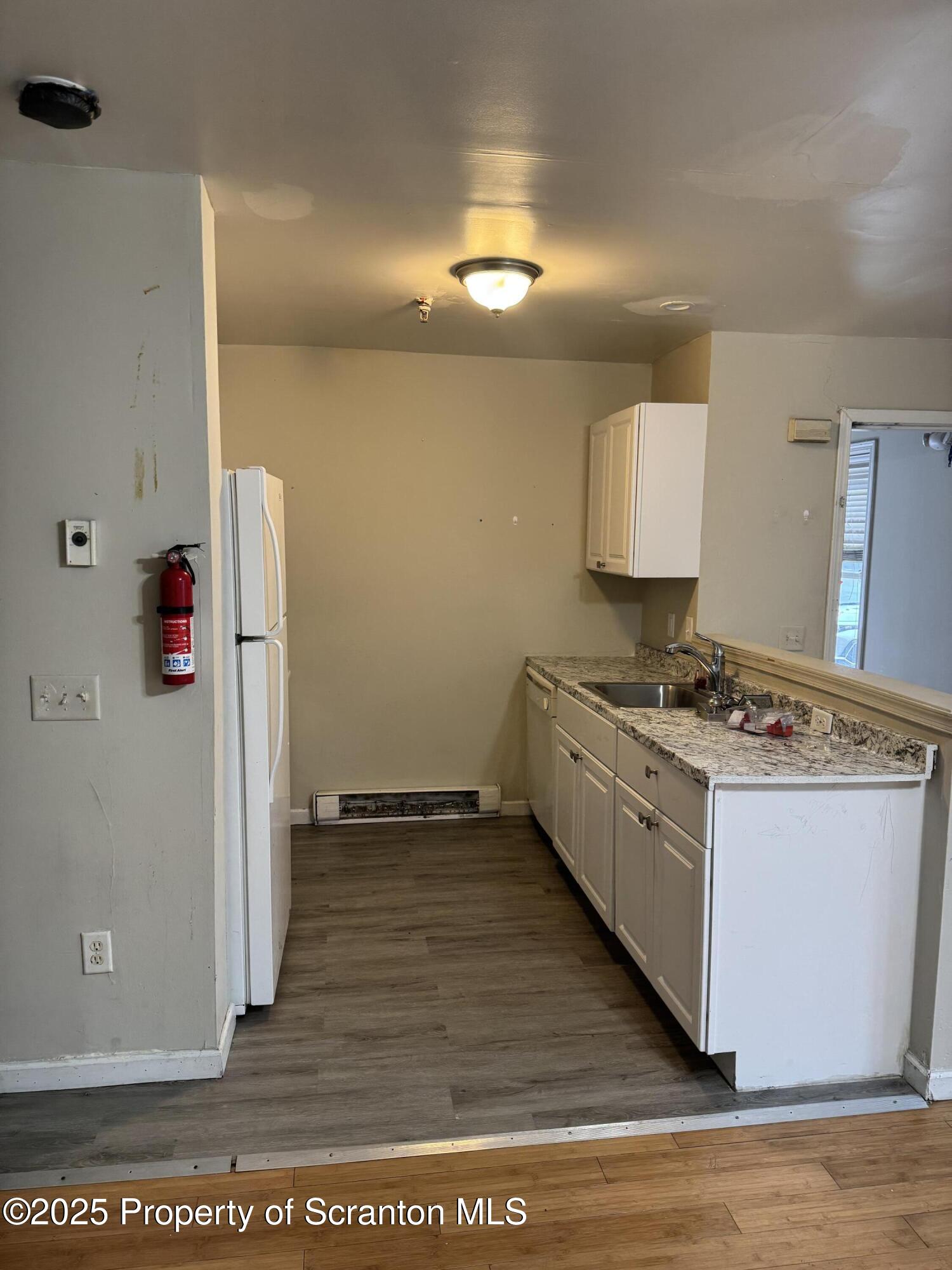 114 Prospect Avenue, Unit 1ST FL FRONT Scranton, PA 18505 - Photo 6 of 10 a kitchen with a stove and a refrigerator