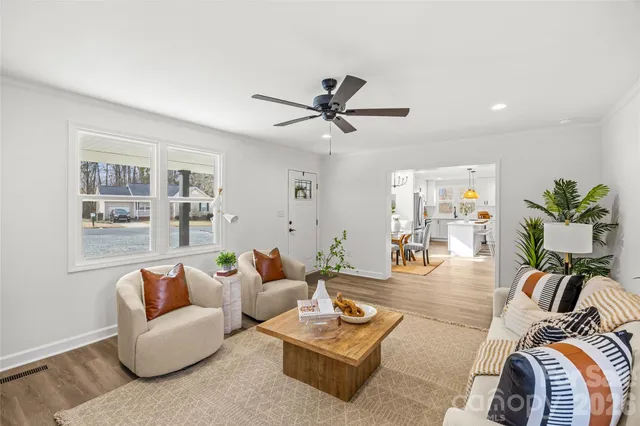 a kitchen with stainless steel appliances a dining table chairs refrigerator and sink