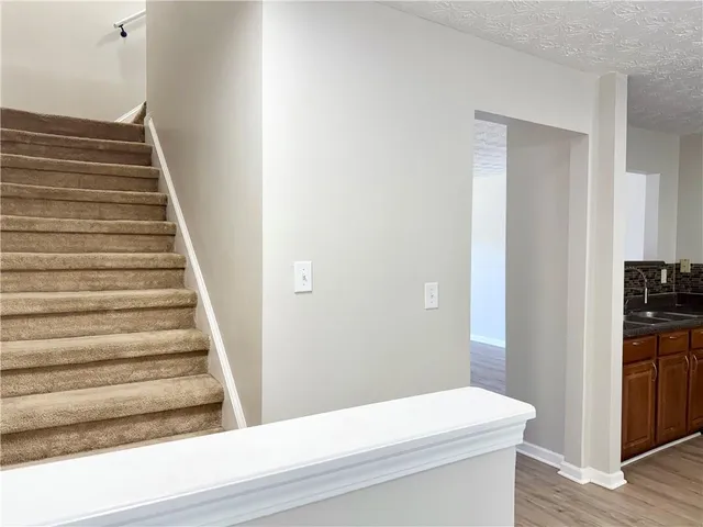 a view of a hallway with wooden floor and staircase