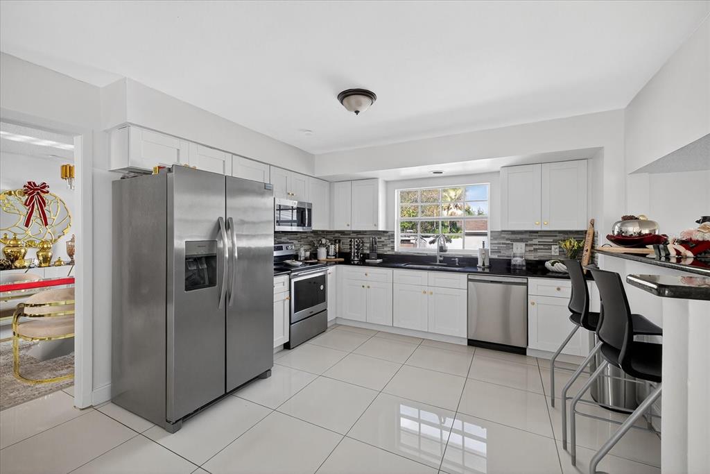 7613 Rustic Drive Tampa, FL 33634 - Photo 36 of 68 a kitchen with granite countertop a refrigerator and a stove top oven