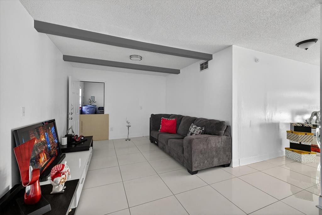 7613 Rustic Drive Tampa, FL 33634 - Photo 40 of 68 a living room with furniture and a flat screen tv