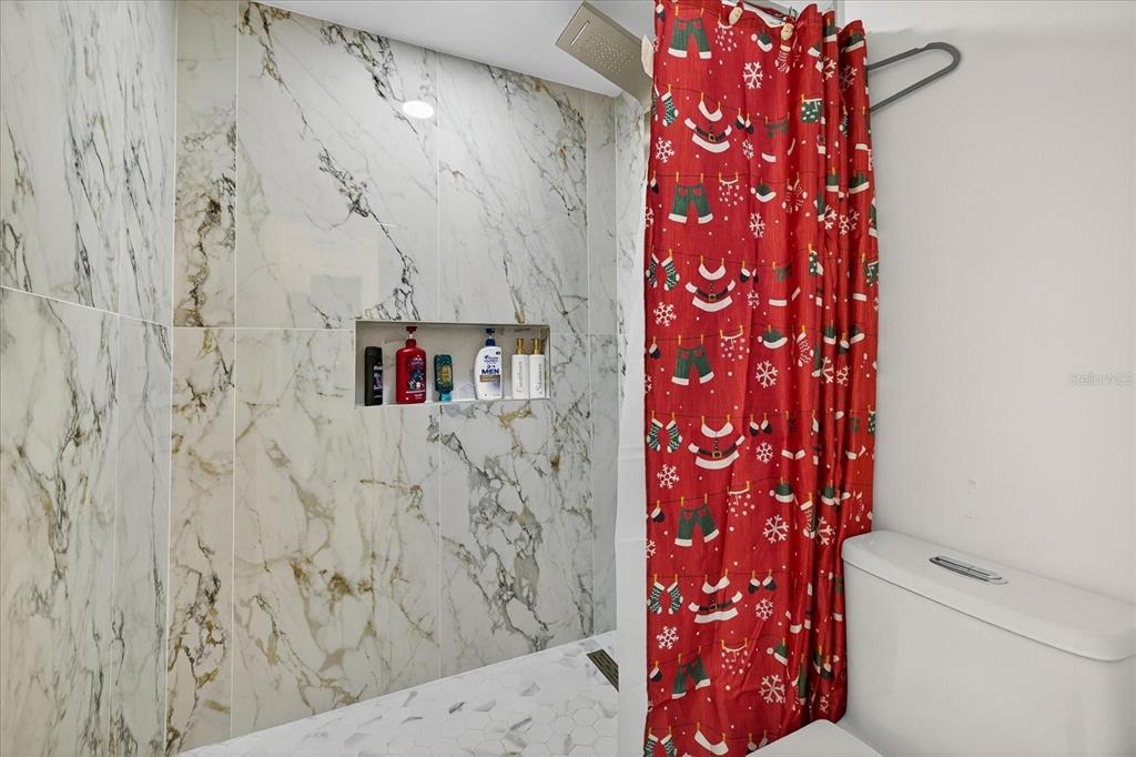 7613 Rustic Drive Tampa, FL 33634 - Photo 53 of 68 a bathroom with a shower curtain and a sink