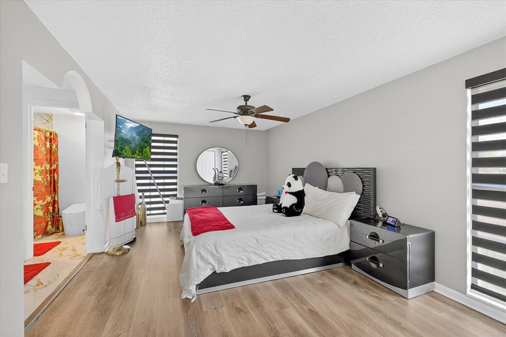 7613 Rustic Drive Tampa, FL 33634 - Photo 56 of 68 a bedroom with a bed and wooden floor