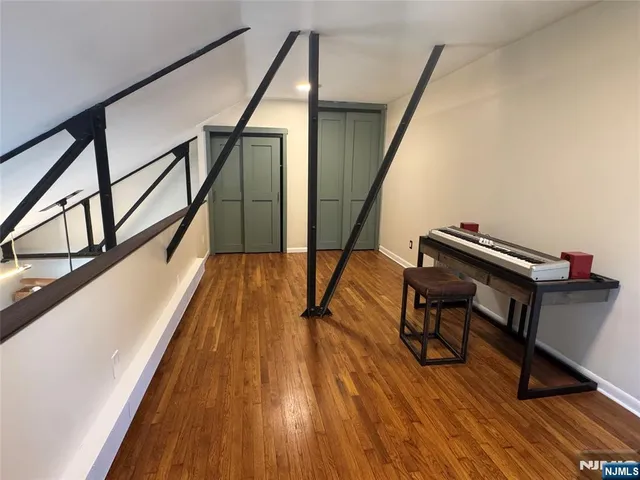 a view of hallway with wooden floor and stairs