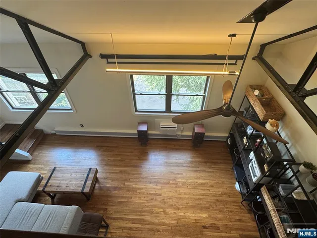 a view of a livingroom with furniture wooden floor and windows