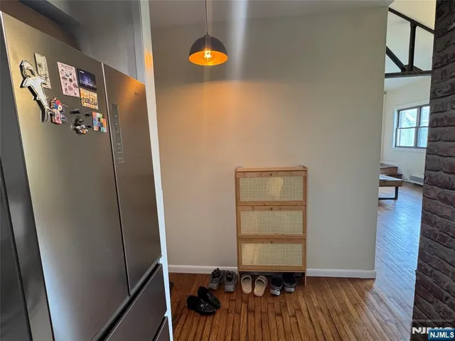 a view of a hallway with wooden floor and closet