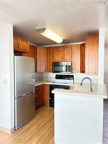 a kitchen with stainless steel appliances granite countertop a refrigerator stove a sink dishwasher and microwave with wooden floor