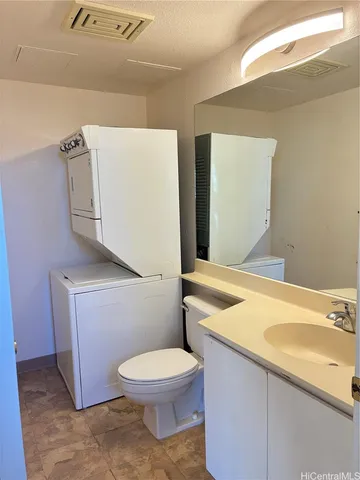a bathroom with a granite countertop toilet and a sink