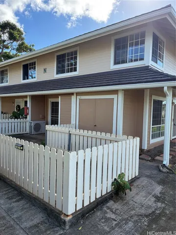 a front view of a house with white fence