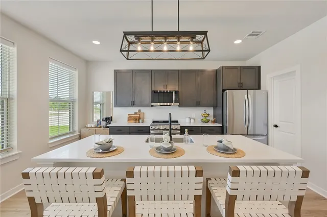 a large white kitchen with a sink and dishwasher with white walls