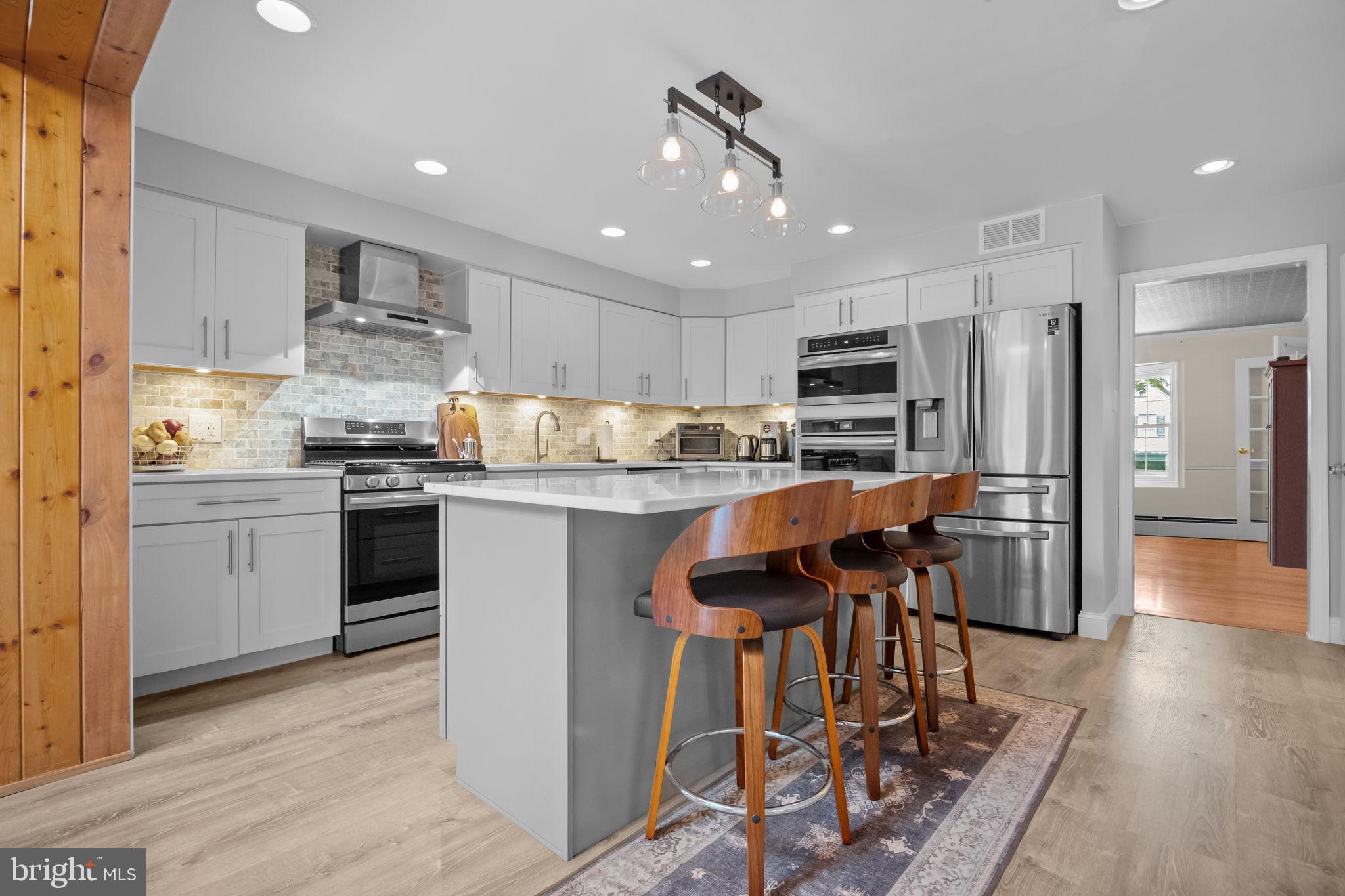 1708 Madeira Avenue Jenkintown, PA 19046 - Photo 14 of 63 a kitchen with stainless steel appliances granite countertop a stove top oven a refrigerator a sink and white cabinets with wooden floor