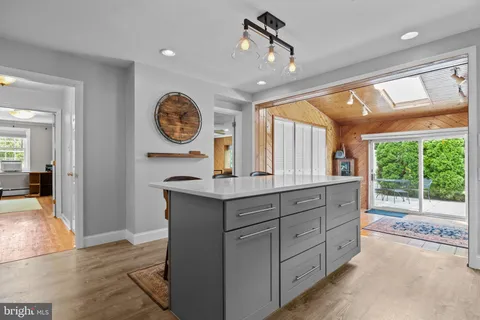 a dining room with furniture floor to ceiling windows and wooden floor