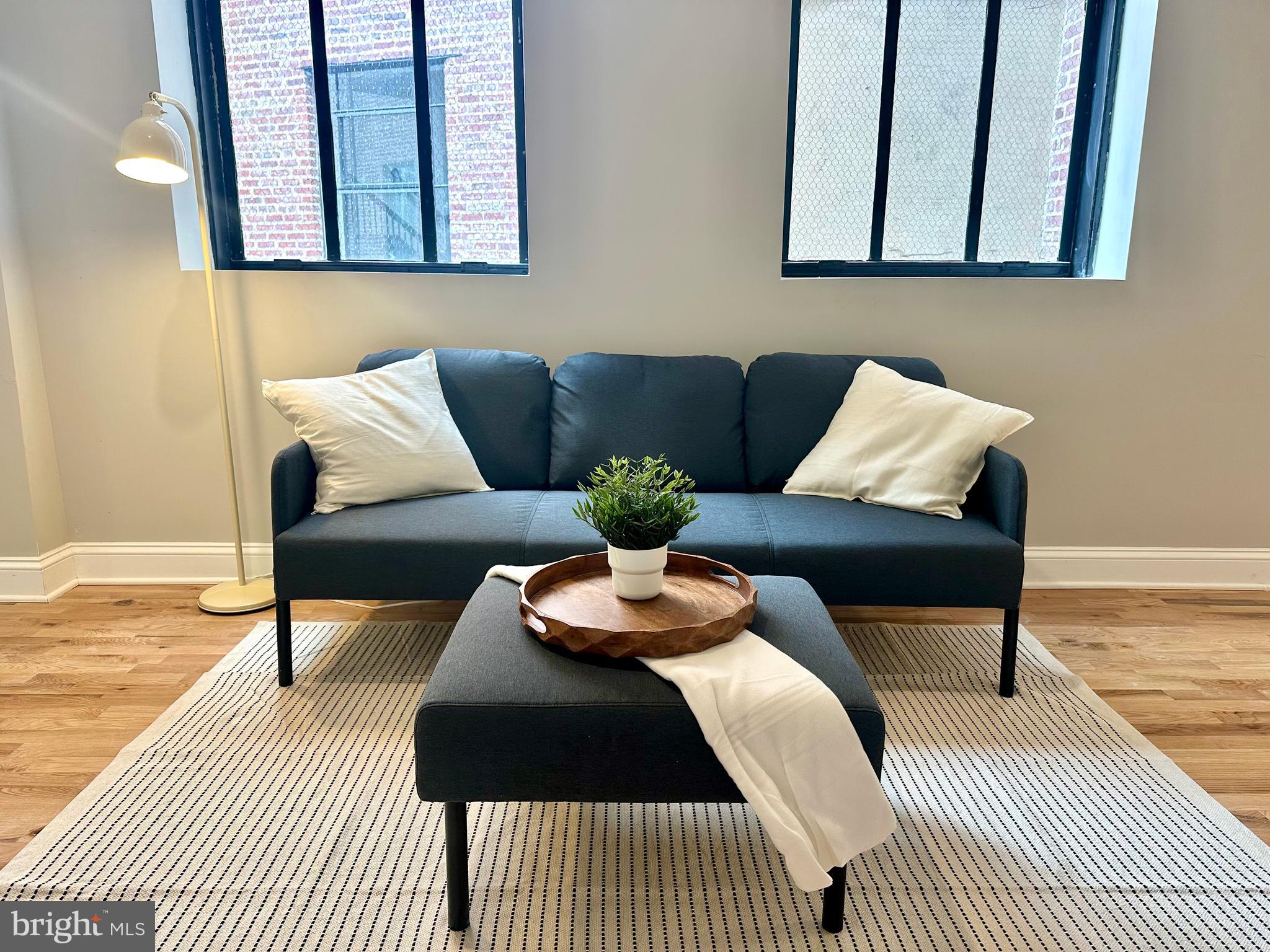 100 West Lexington Street, Unit 404 Baltimore, MD 21201 - Photo 12 of 27 a bedroom with a bed a couch and a potted plant