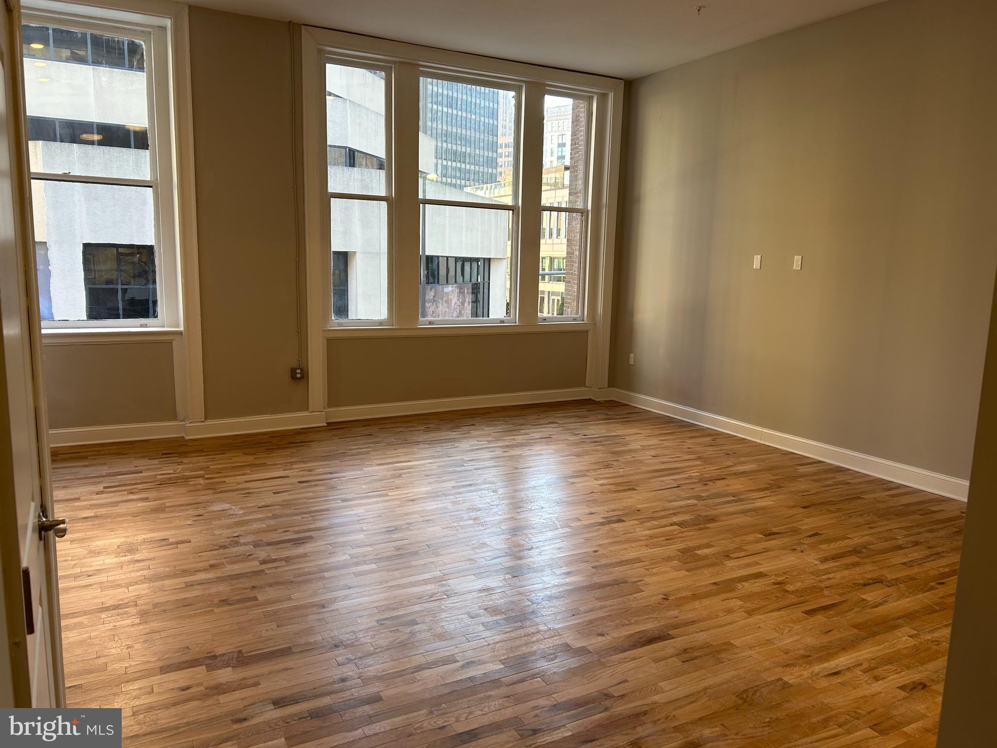100 West Lexington Street, Unit 404 Baltimore, MD 21201 - Photo 3 of 27 a view of an empty room with wooden floor and a window