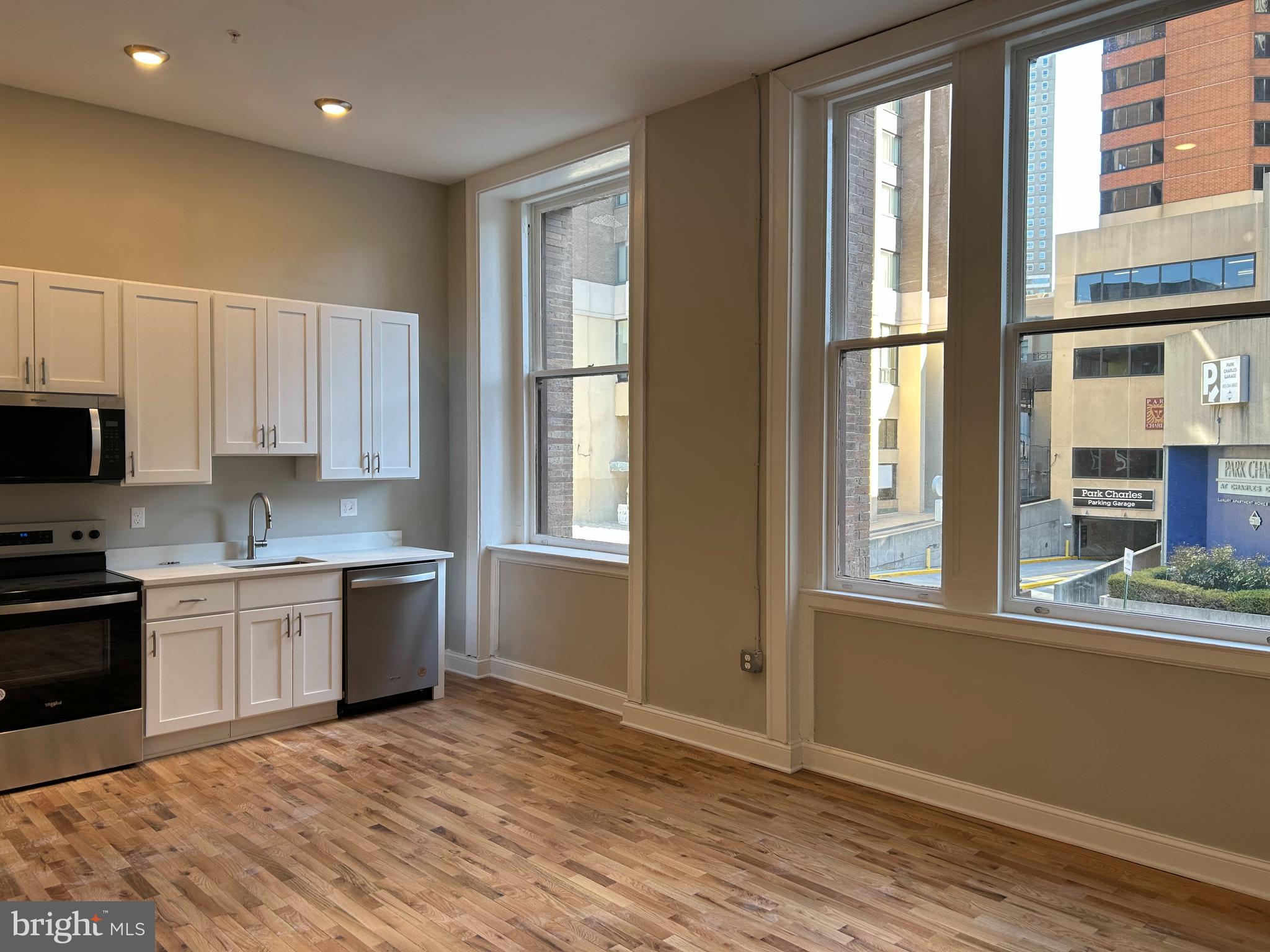 100 West Lexington Street, Unit 404 Baltimore, MD 21201 - Photo 5 of 27 a kitchen with granite countertop a stove a sink and a refrigerator