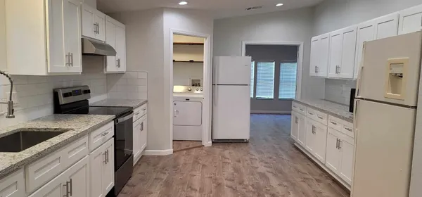 a kitchen with granite countertop a sink stove and refrigerator